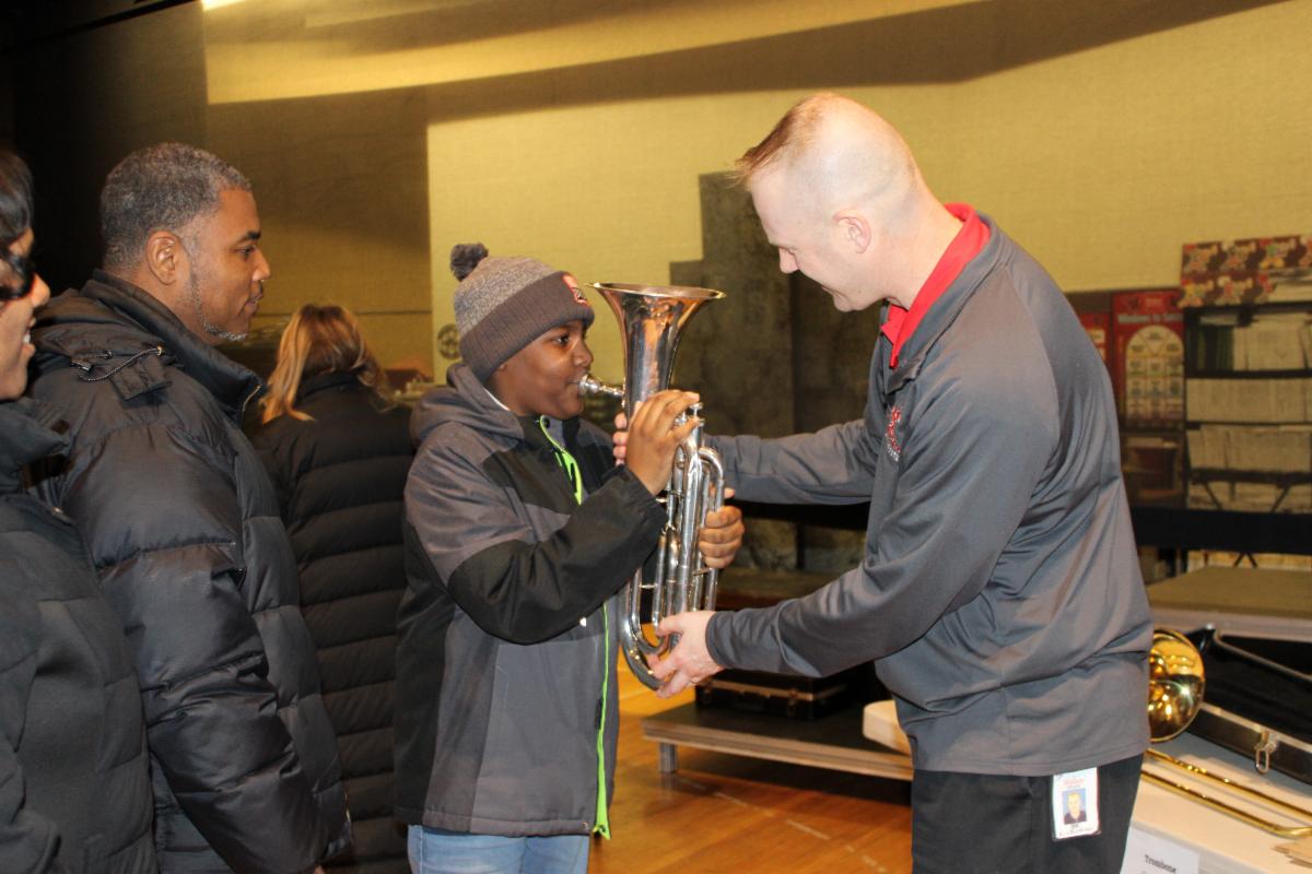 Band Director Joe Kulikowski helps a student learn a baritone instrument.