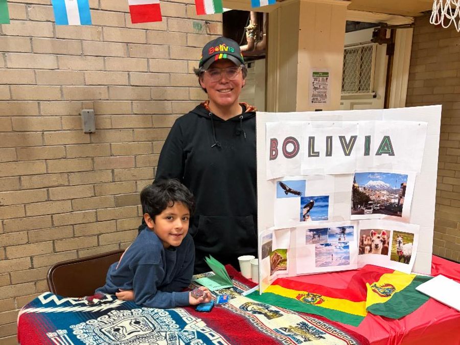 A Boulevard student and his dad pose next to their Bolivia trifold board.