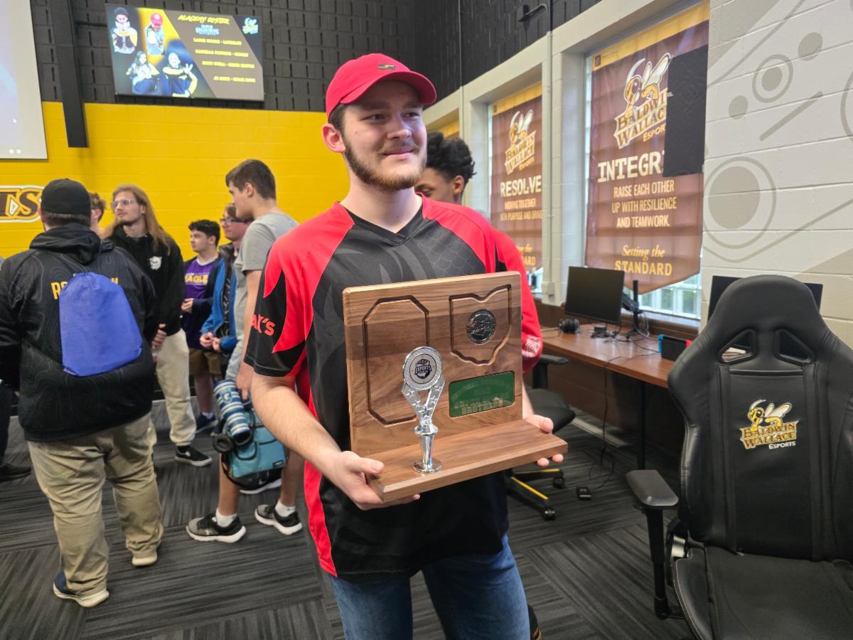 A student on the SHHS Esports team holds an OHSAA trophy.