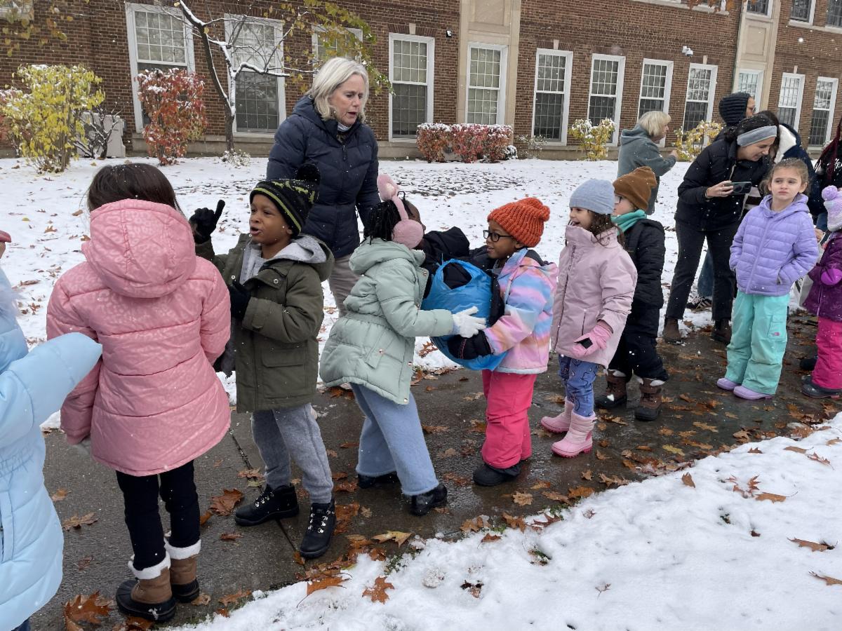Mercer students pass donations down a line outside of the school building.