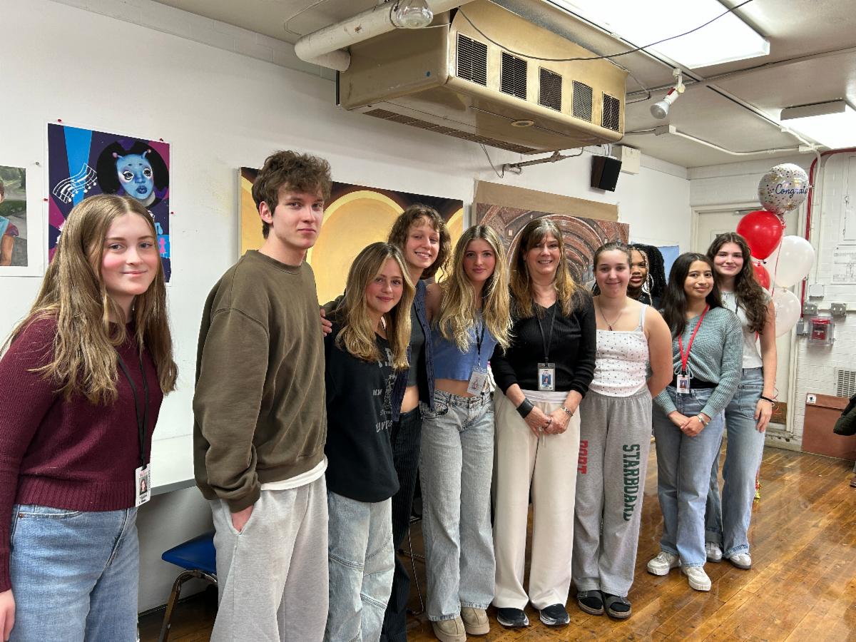 Shaker Heights High School Art Teacher Karen Mehling-Howson stands with a group of students in the art room after receiving her Excellence in Teaching Award.