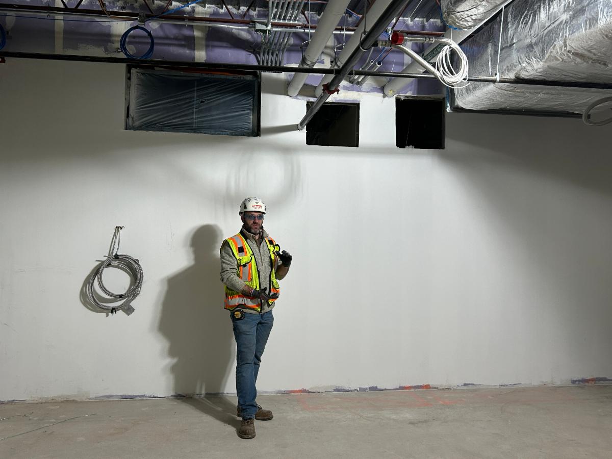 A construction worker stands in a freshly-painted Ludlow classroom.