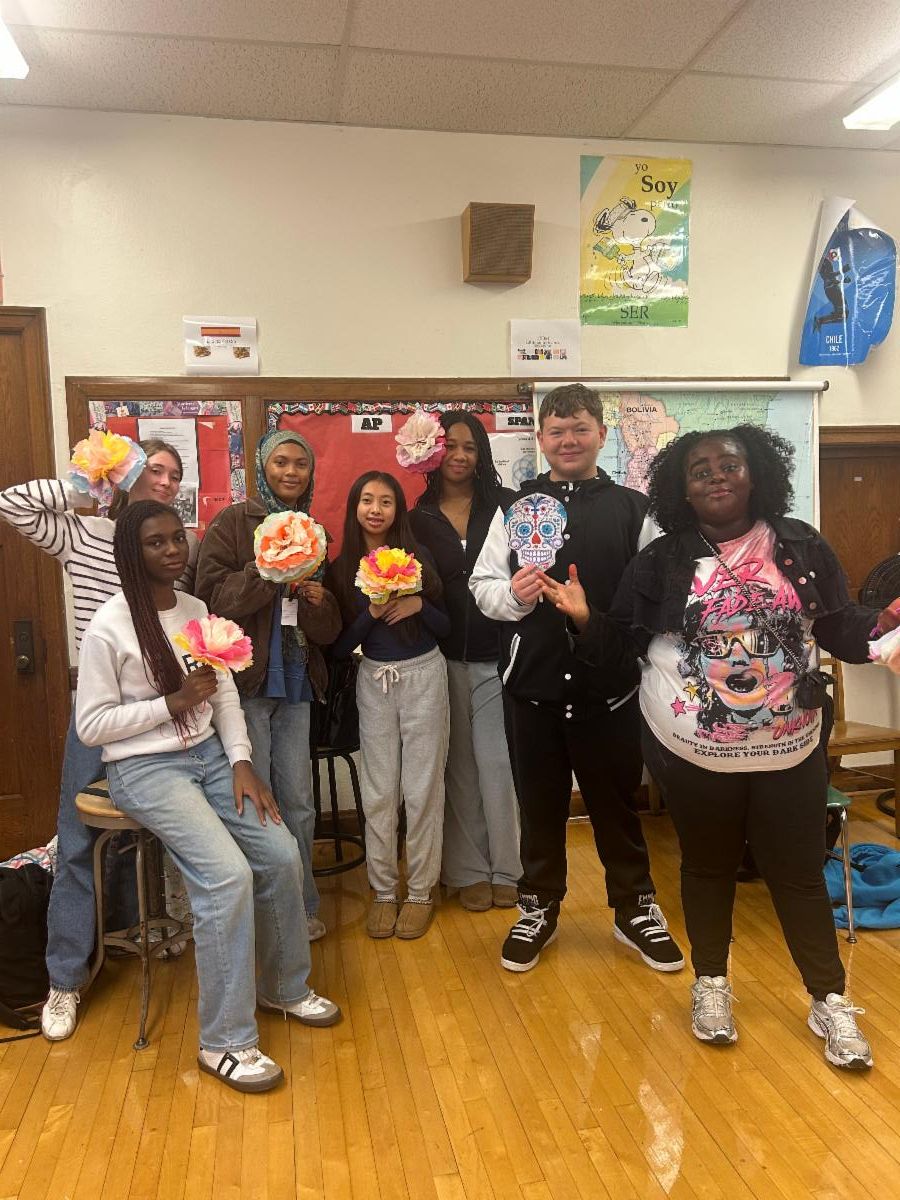 Spanish students pose with paper flowers they made to celebrate Day of the Dead.