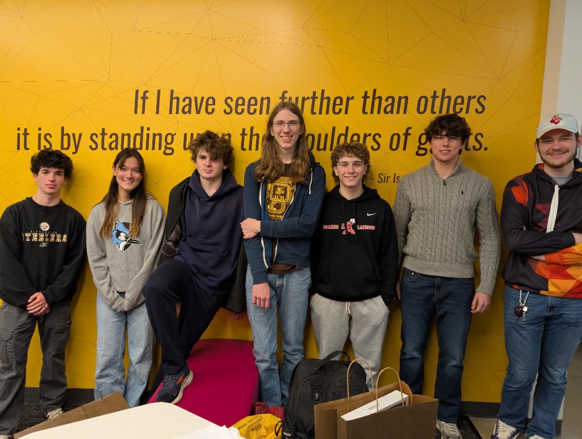Seven students on the SHHS Coding Team stand against a wall after their recent victory.