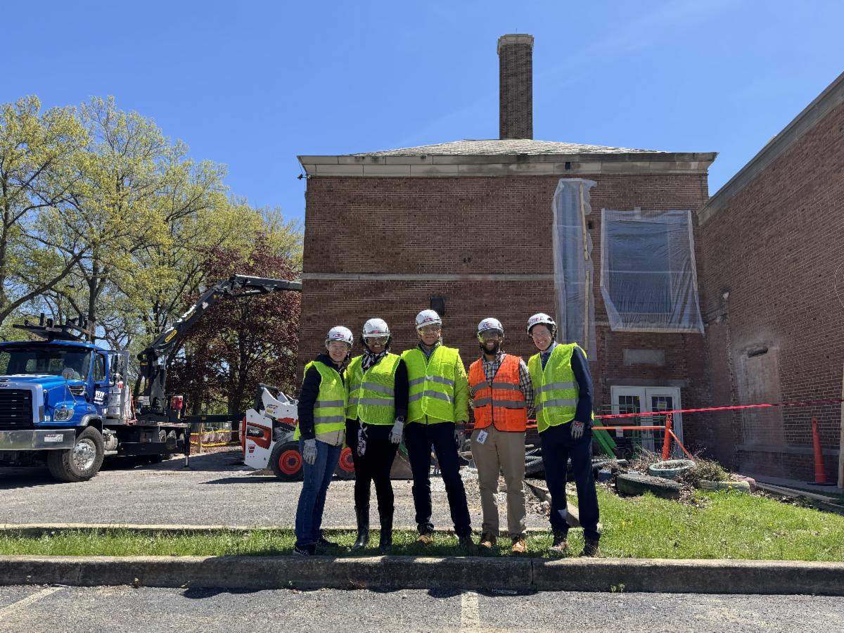 District administrators stand outside of Ludlow in safety gear after a tour of the building while under renovation.