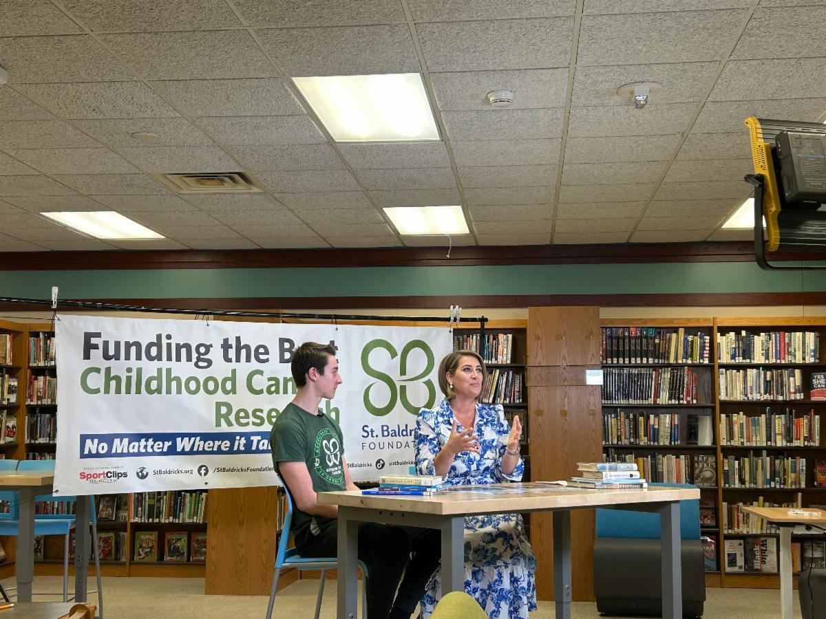 Shaker Heights High School Senior Quinn Malone sits at a table for an interview with Channel 19 Reporter Jamie Sullivan about the St. Baldrick's event.