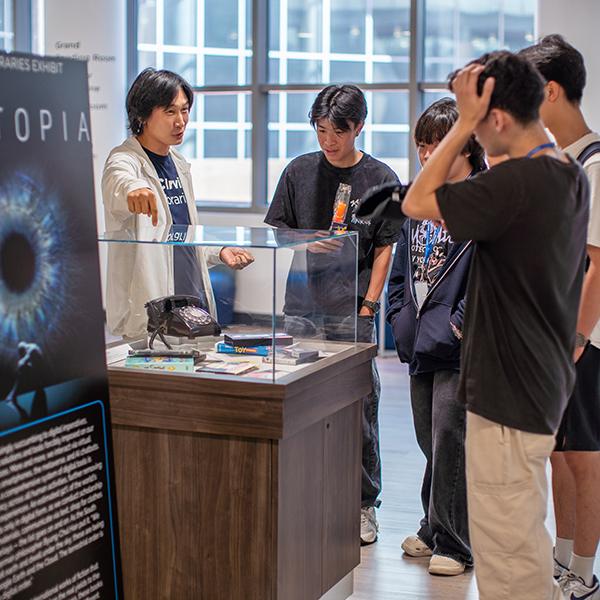 Librarian Richard Cho showing UCI students Science Library exhibit