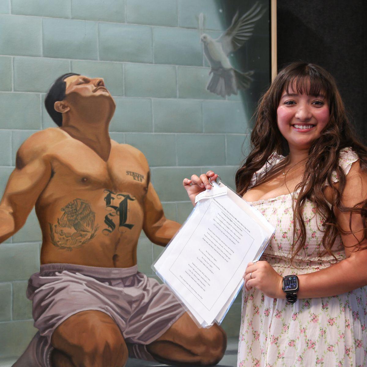 A UC Irvine student with a written piece and visual artwork. The visual artwork shows a man on his knees facing upwards with his arms outstretched. A brick wall is behind him and a white dove is above him.