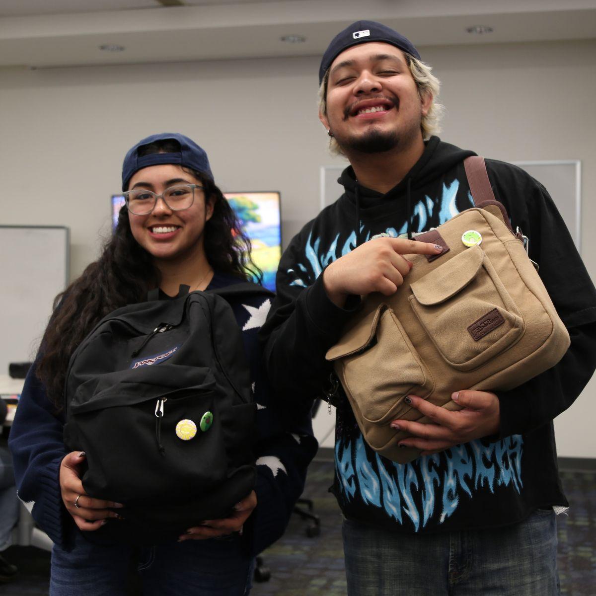 UC Irvine students showing their backpacks with pin-back buttons that they made.