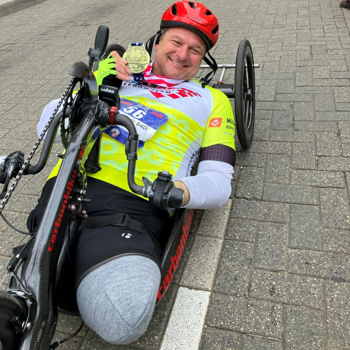 John Masson with his finisher medal in a handcycle