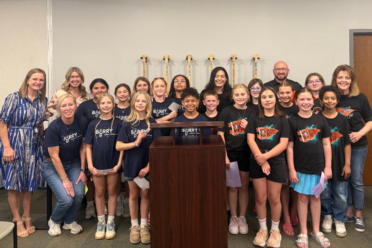 students and staff posing at the board meeting