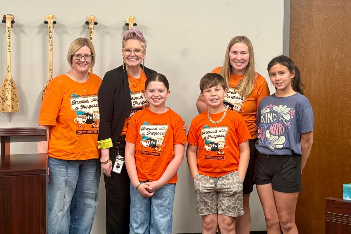 students and staff posing at the board meeting