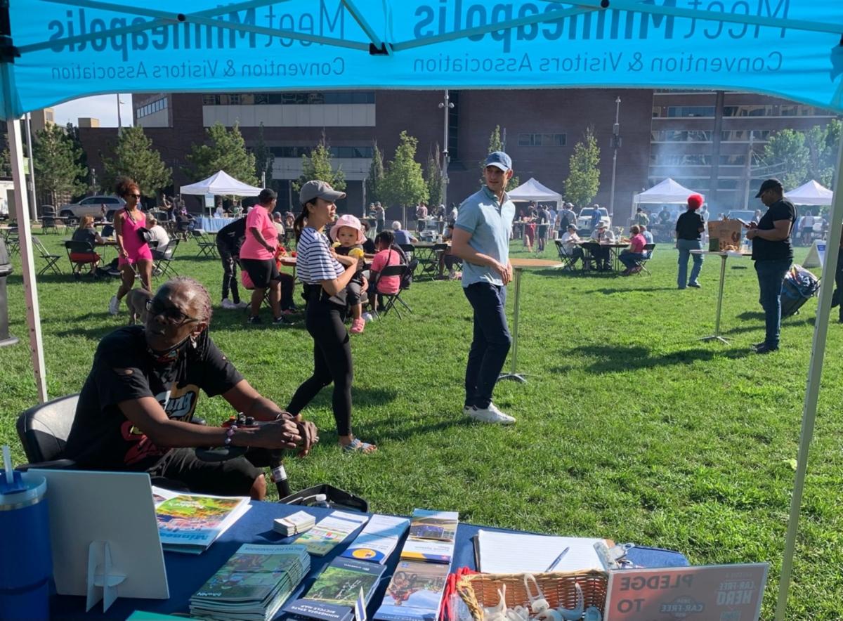 Downtown residents stop to chat at the shared booth between Meet Minneapolis and Move Minneapolis during National Night Out