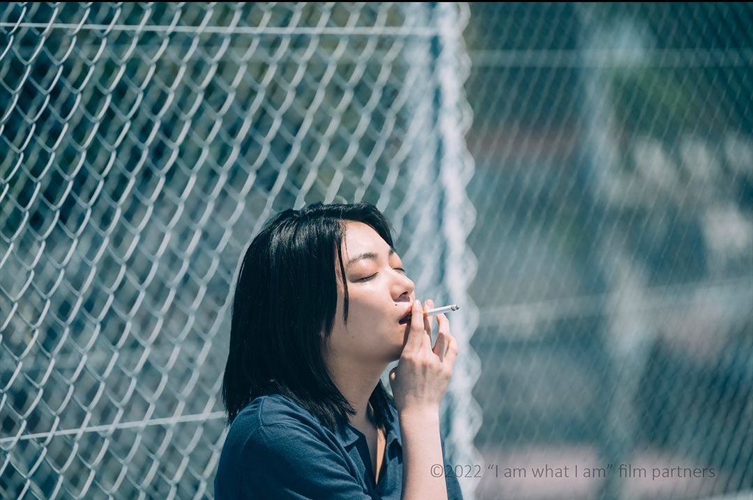a woman smoking a cigarette in the film i am what i am