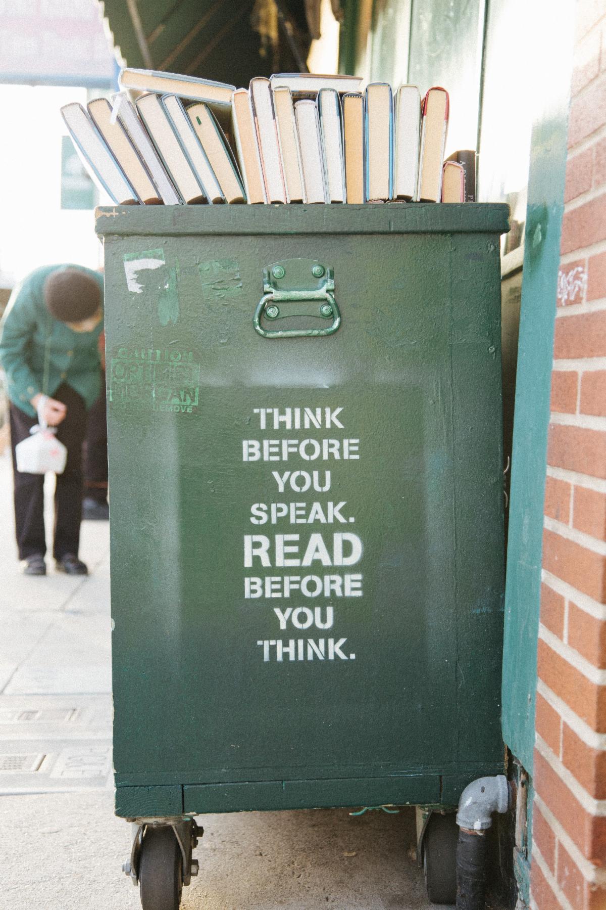 Photo of a waste bin with words painted on it: Think before you speak. READ before you think.