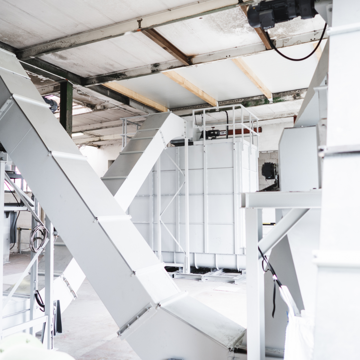 Industrial film recycling system with enclosed conveyors and processing equipment installed inside a production facility.