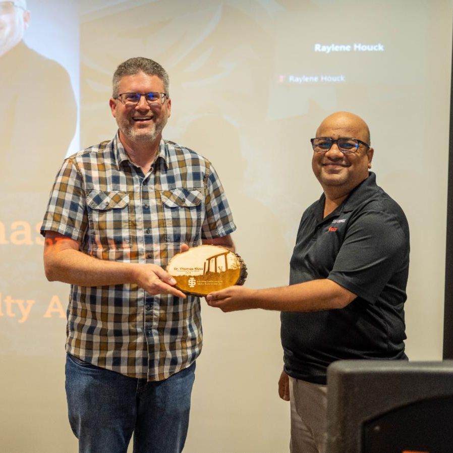 Tom Kloss receives an award plaque