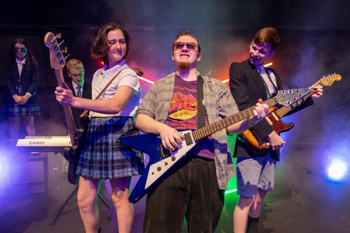 characters on stage play guitars