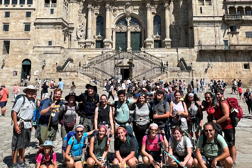 Group of people in front of an ornate historical building with Baroque architecture.