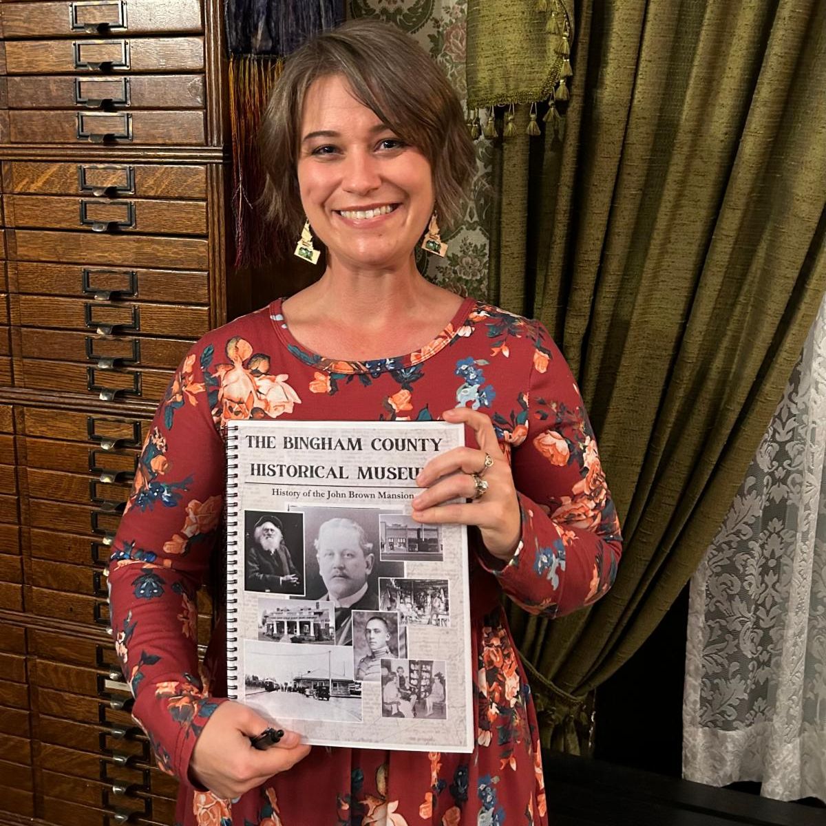 Headshot of Andrea King holding a copy of her book