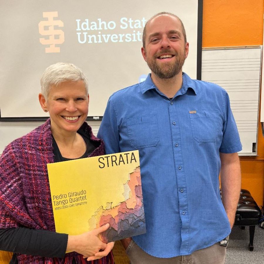 Jon and Nell stand together holding the Strata album