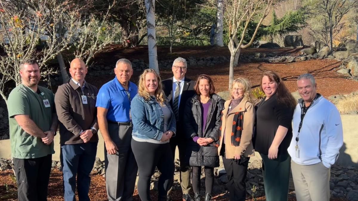 Group photo of the following folks standing outside in front of trees: Alex Daniels (Phlebotomy Supervisor, Mercy) Frank Rambaum (Director of Laboratory Services, Mercy) Ines Wenger Jindra (Social Work, ISU) Kandi Turley-Ames (Social Work, ISU) Rachel Hulse Med (Lab Science, ISU) Randy Hubbard (Dean of Advanced Medical Program Partnerships, UCC) Rex Force (Vice President, ISU) Russ Woolley (President, Mercy) 