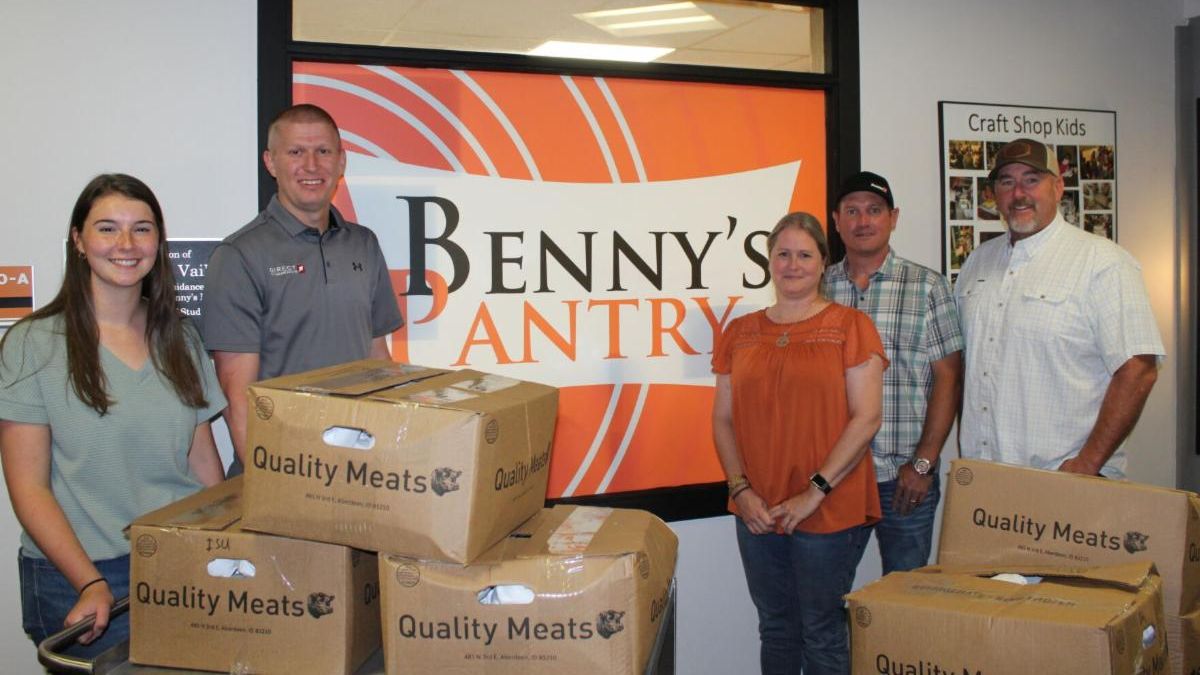 Group photo of 5 people including Tim May and boxes of meat