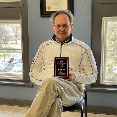 Andy Christensen holds his plaque for Alumni Achievement of the Year award