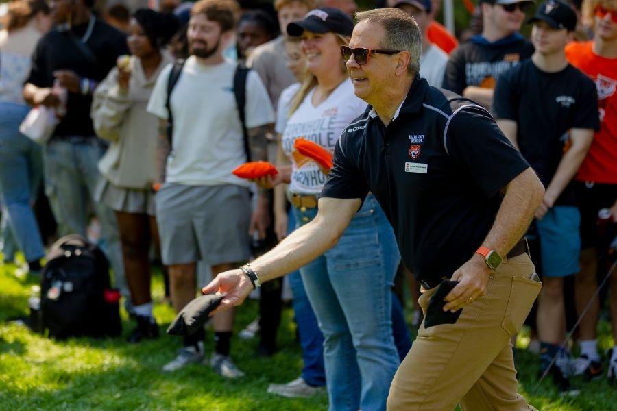 President Wagner throws first toss at the cornhole tournament