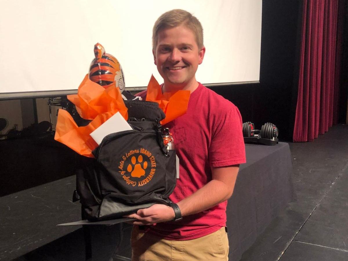 Picture of Jaxon Jensen holding a gift bag from ISU and smiling