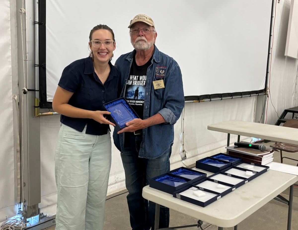Maya posing with an award
