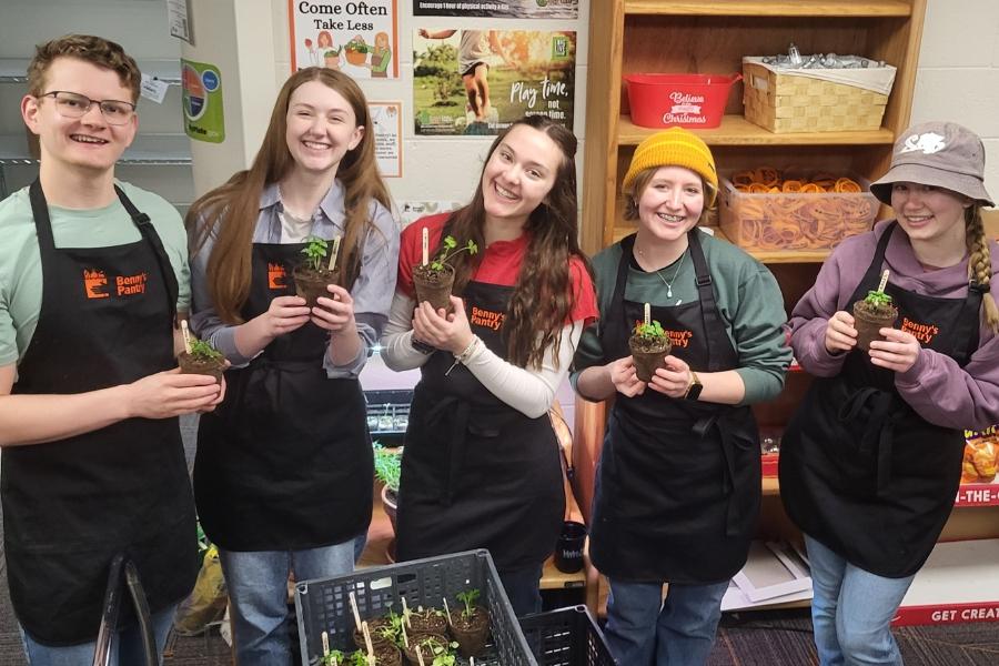 Volunteers at Bennys Pantry holding plants