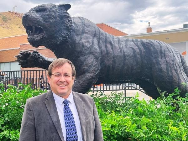 Jeffrey Francom stands in front of the bronze bengal tiger statue