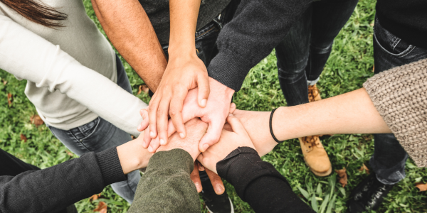 Individual's hands stacked on top of each other