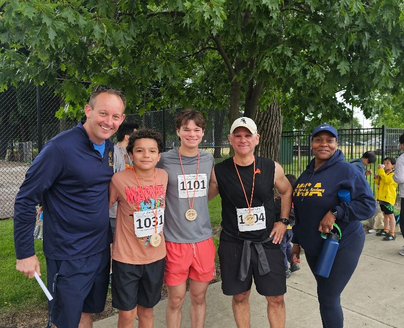 a group of runners post race standing in front of a tree.