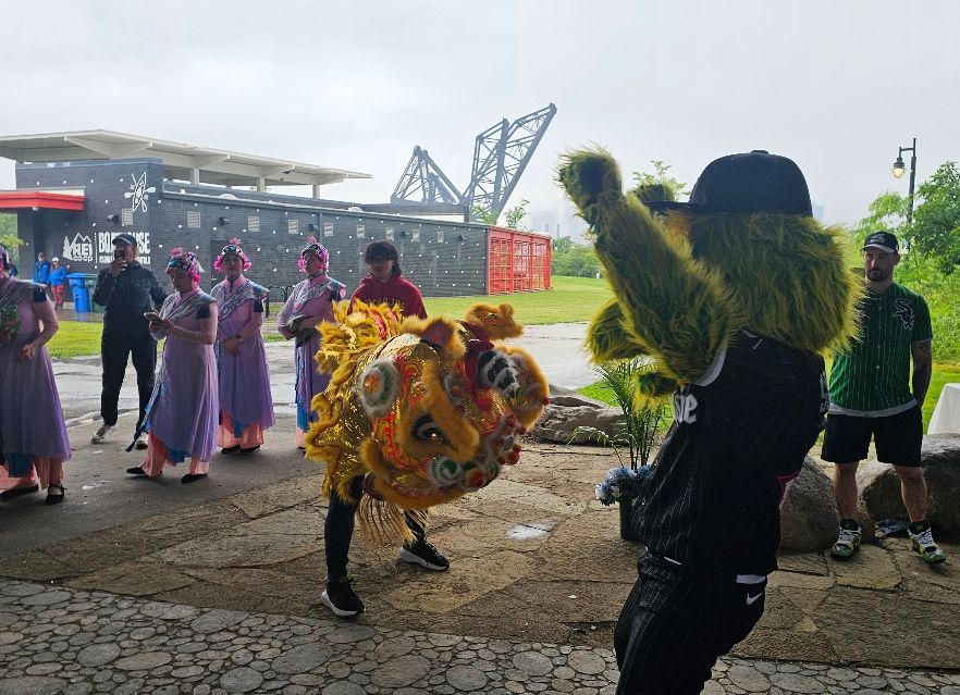 Ping Tom Park - Chinese Lion Dance with SouthPaw, boathouse and city skyline in the background.