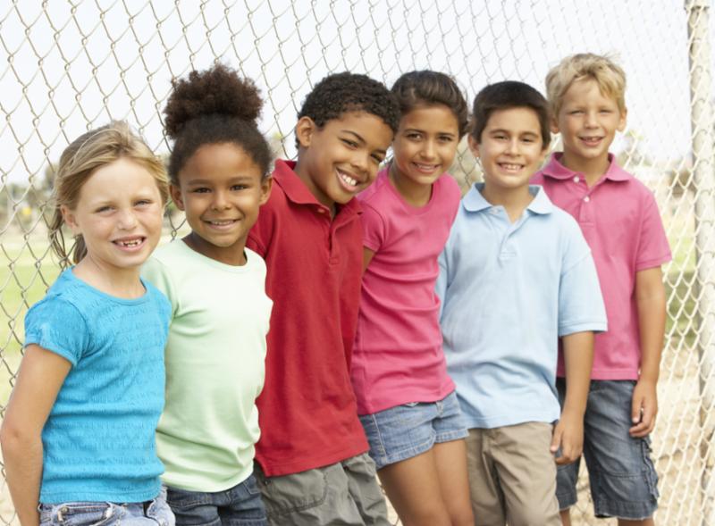 children_smiling_by_fence.jpg