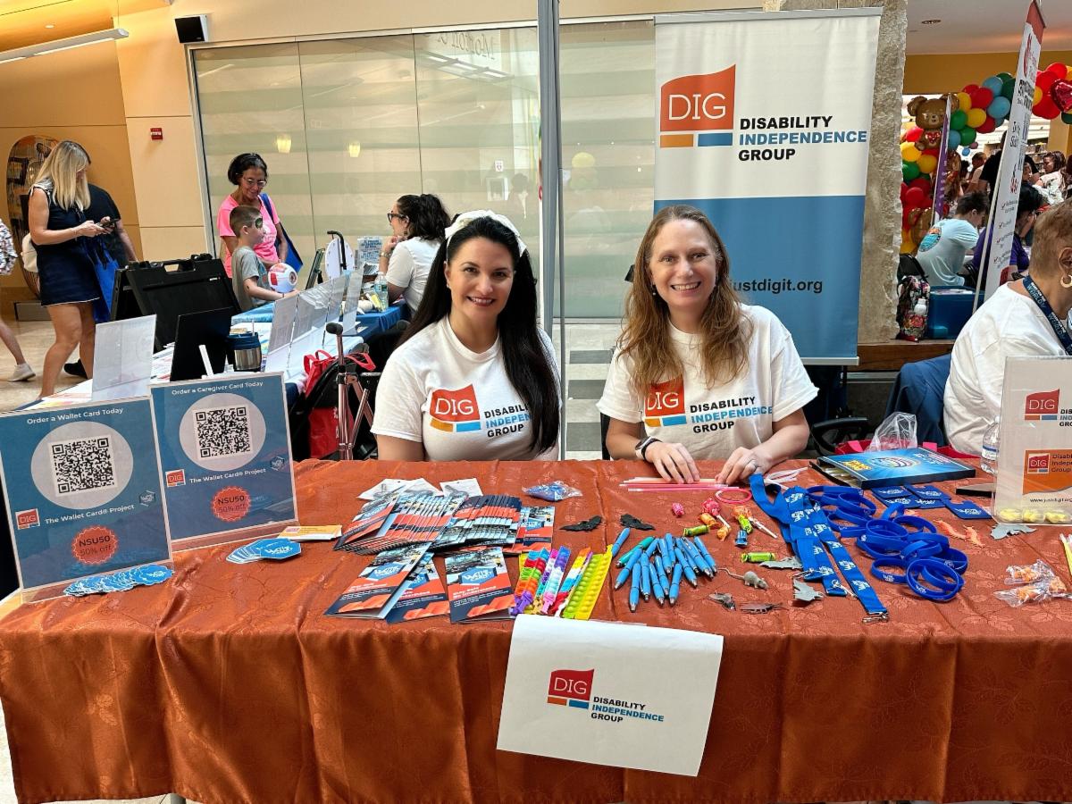 Photo of Justine and Debbie sitting at a table at at A Day for Children event