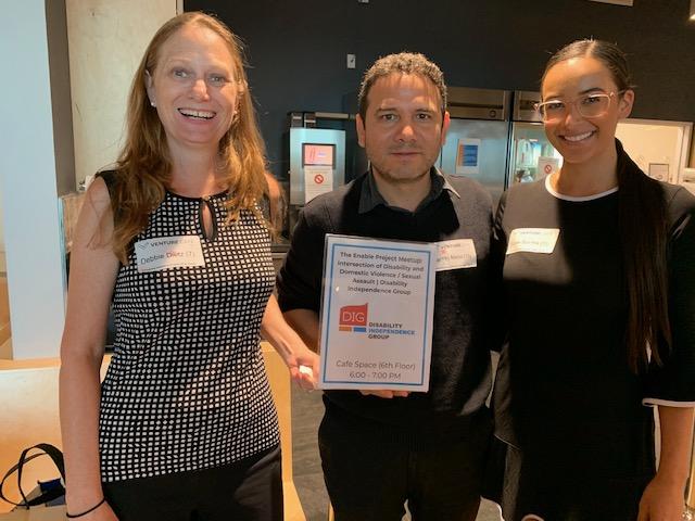 debbie camilo and catalyst staff at the venture cafe holding a sign about the enable project.