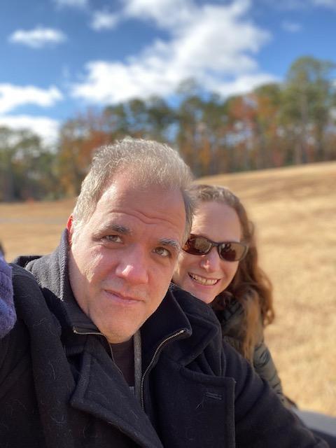 debbie and matt smiling with fall trees in the background