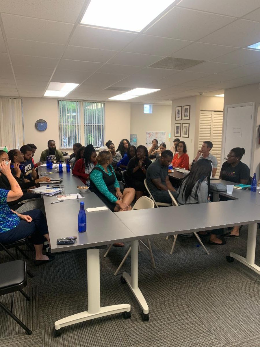 unite miami training at the DIG office with people sitting at tables and talking
