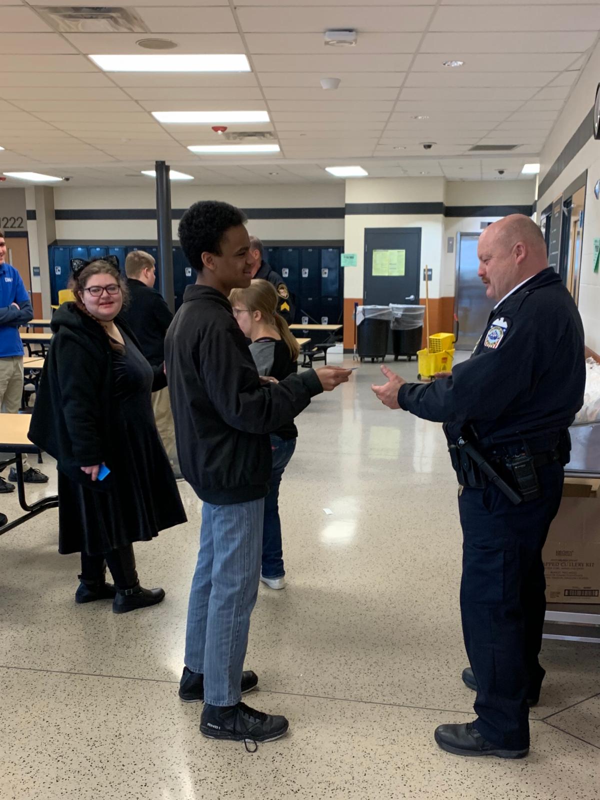 A SWCSD Project Life Intern standing with his wallet card practicing how to safely use his wallet card with a police officer
