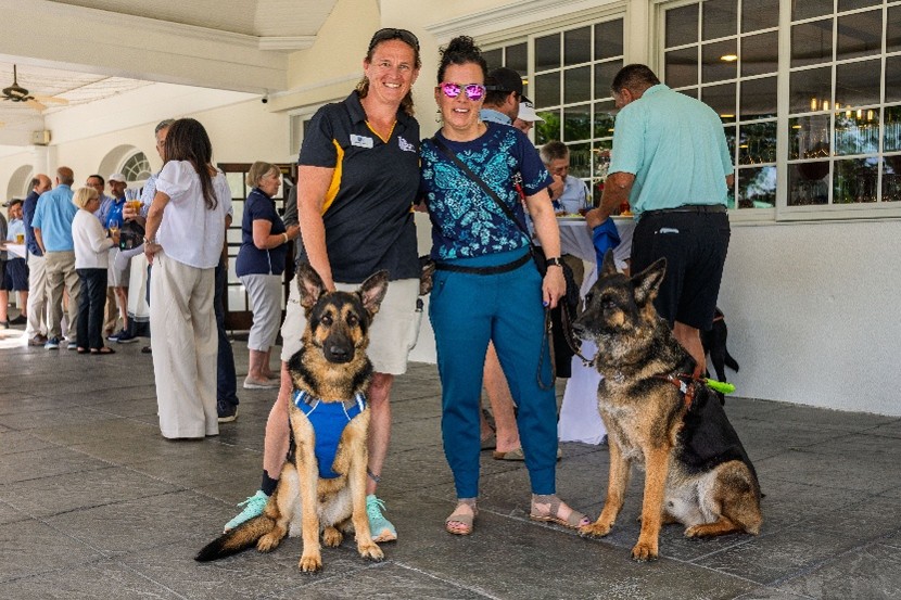 Shawn and Jolene Hollister smile for the camera with German Shepherds Steinway and Nick seated beside them.