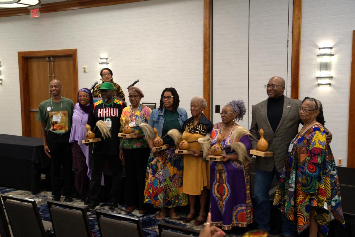 The Black Appalachian Storytellers stand in a row holding gourds