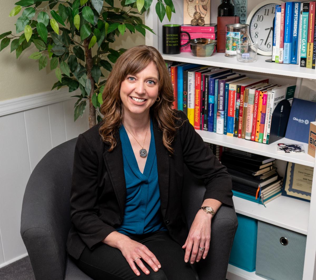 Headshot of Dr. Elaine Grogan Luttrull sitting in a chair in front of a bookshelf