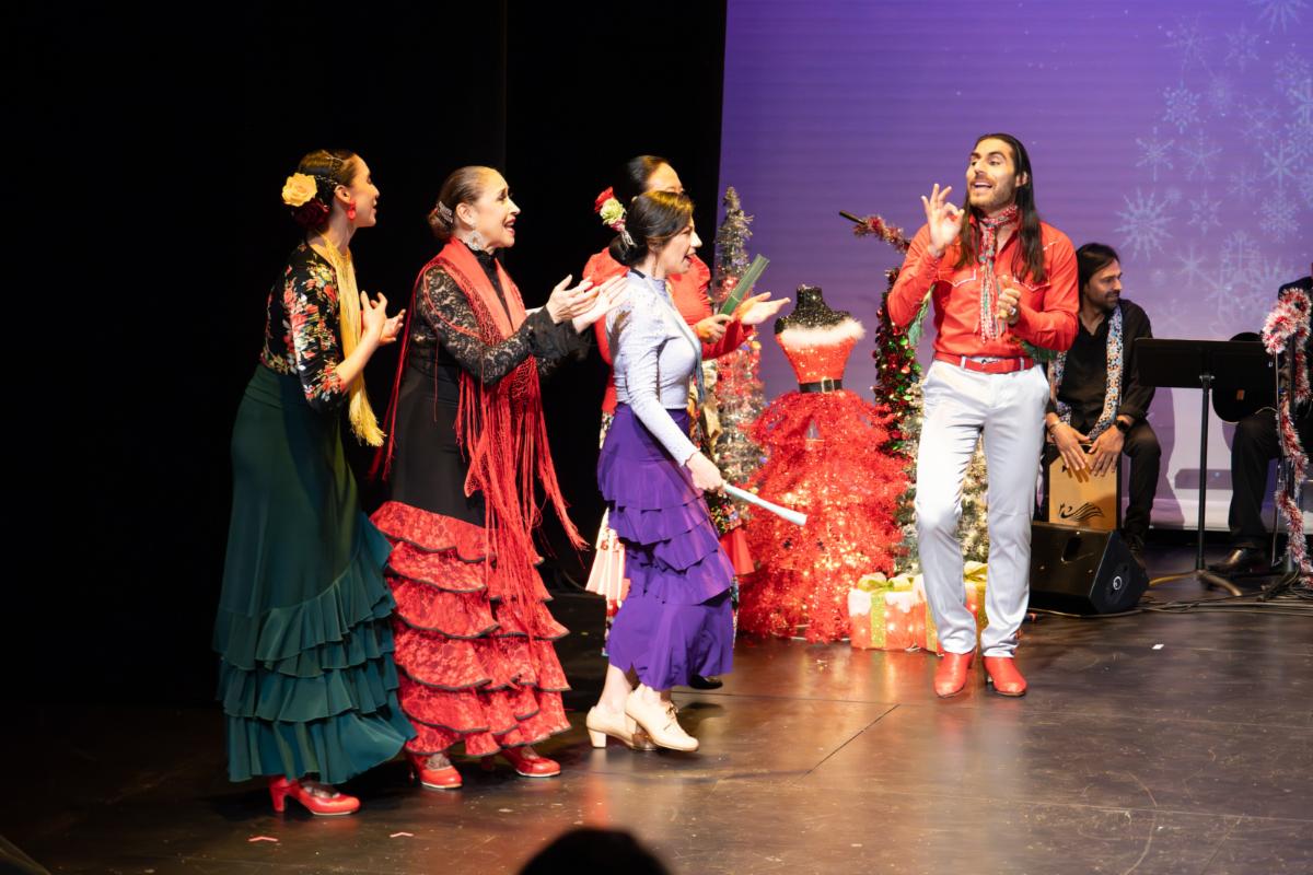 A flamenco ensemble performs in festive Christmas attire on stage
