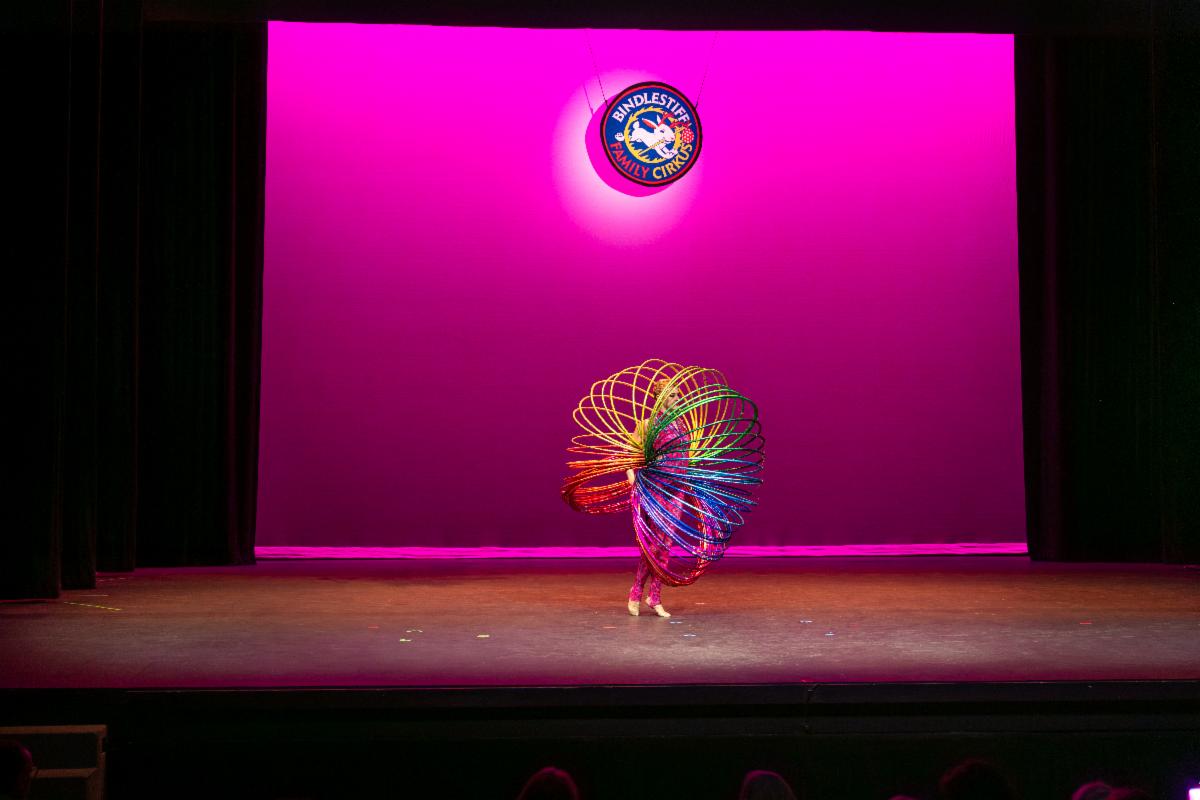 A performer with many spring-like hoops on a stage