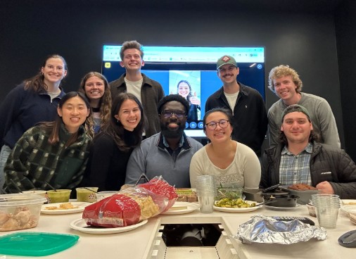 Members of YMF smile for the camera while seated at a table during trivia night.