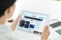 Person holding tablet, reading news