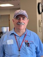 Man with gray hair and baseball cap, smiling